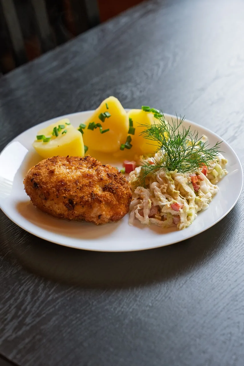 Kotlet panierowany z młodymi ziemniakami i surówką